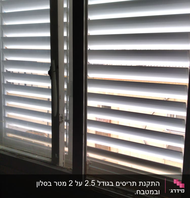 תריסי אלומיניום לבנים על חלון זכוכית